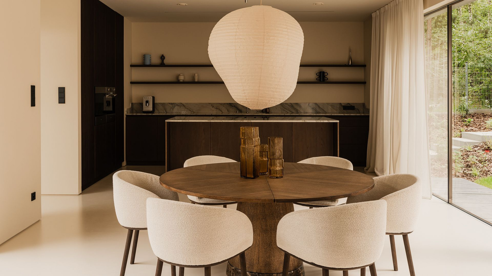 Dom w stylu japandi otoczony lasem. Przeszklone atrium zapewnia przestrzeń do odpoczynku