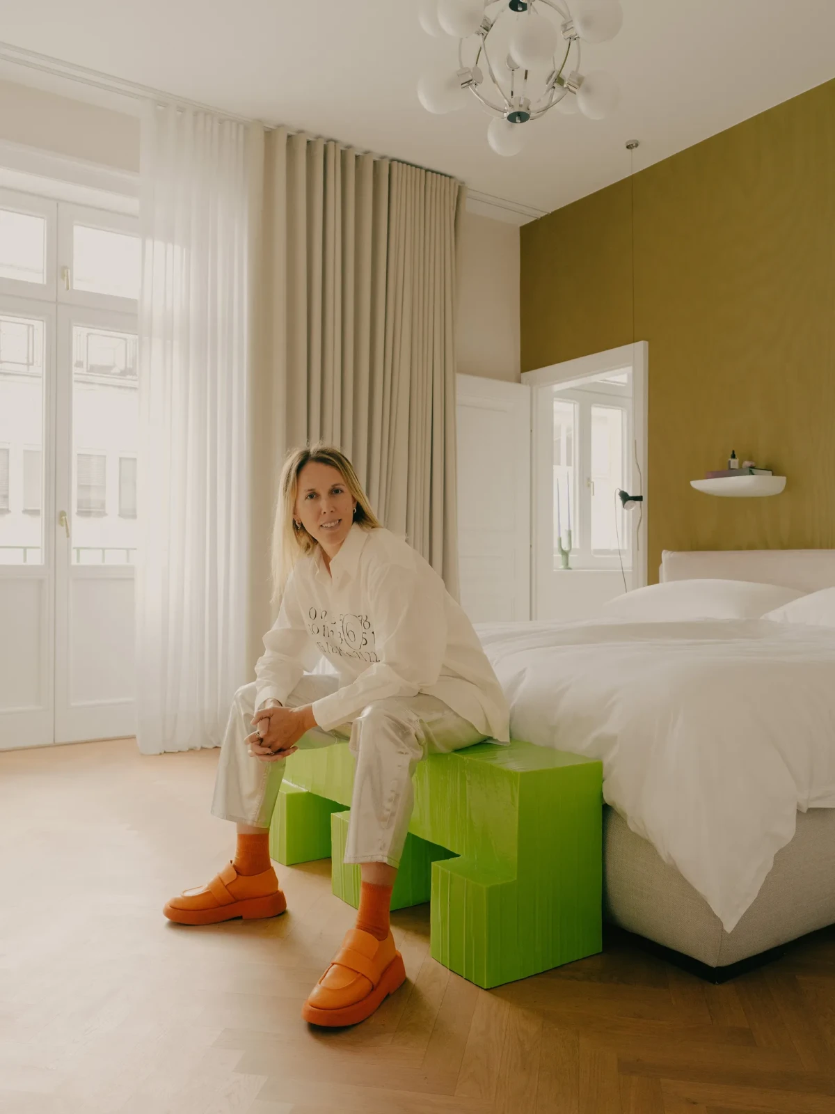 Kathrin Schaden na błyszczącej, zielonej ławce „Jello” autorstwa Marco Campardo i Juliusa Hirtzbergera